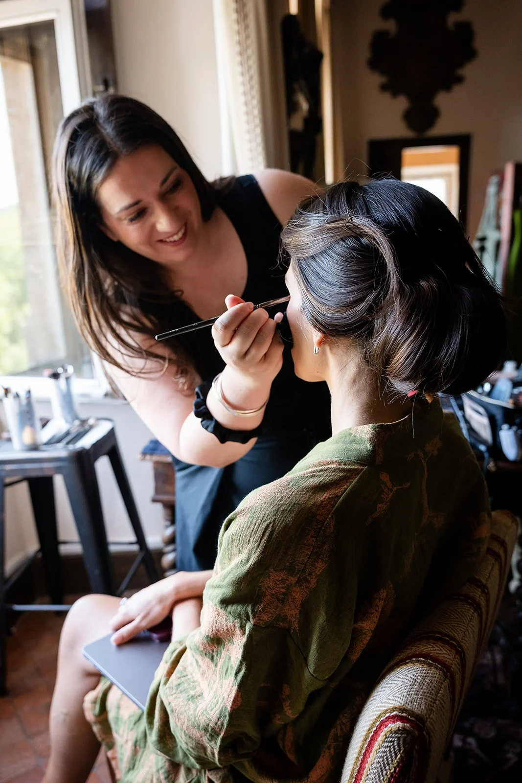 Makeup artist applying makeup to a bride on her wedding day