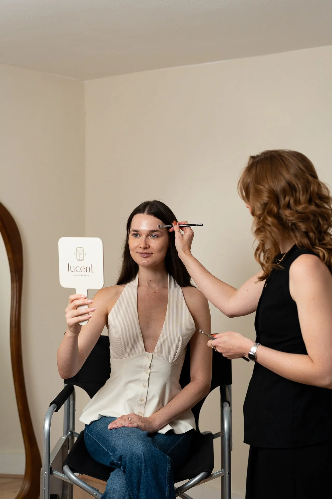 a woman having her makeup applied during a makeup masterclass by Lucent Hair & Makeup
