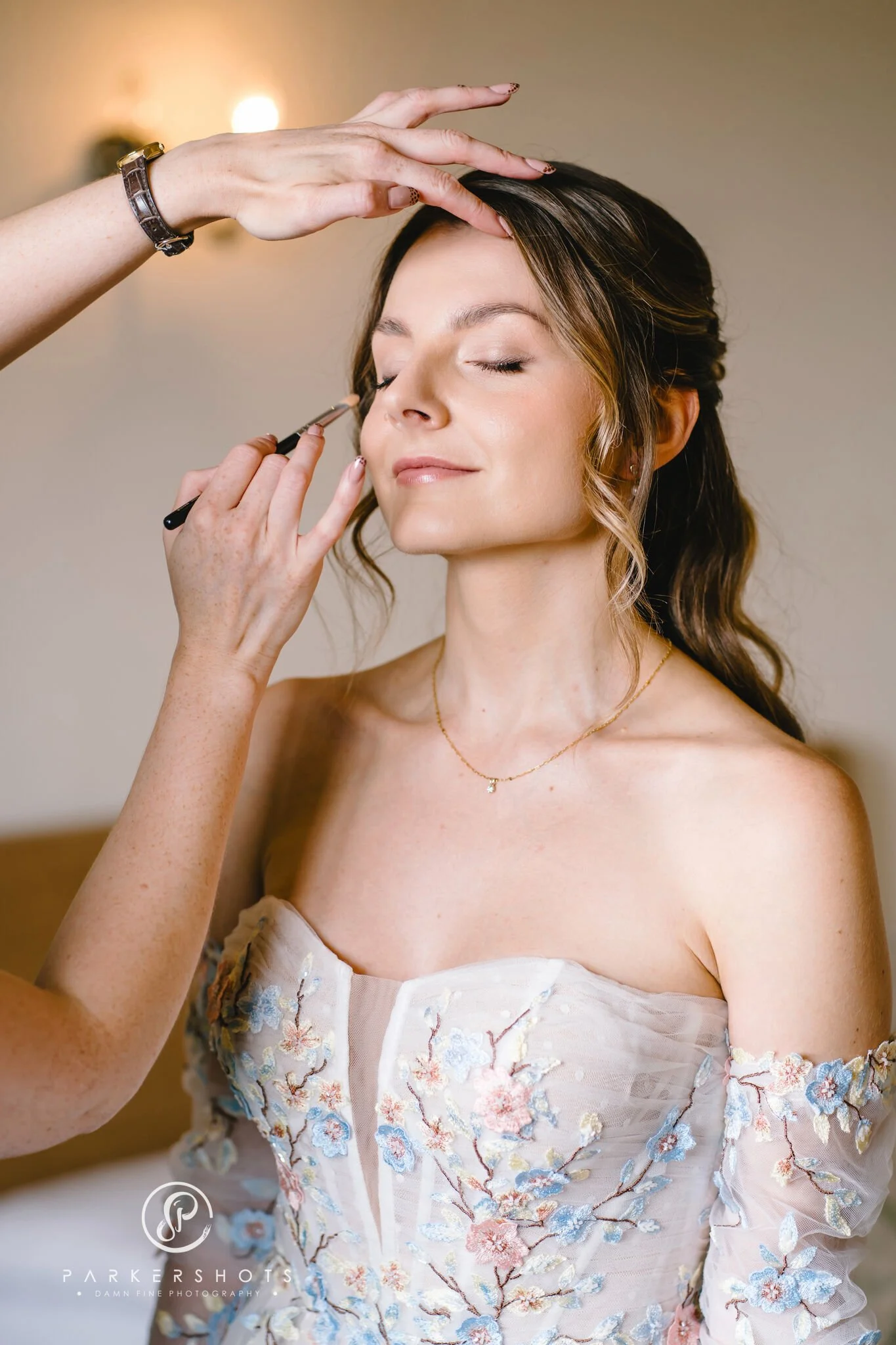 Bride having her makeup applied on her wedding day