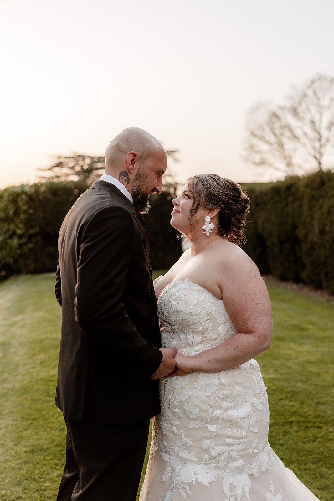 a bride and groom hold hands, standing in the garden at Hedsor House wedding venue