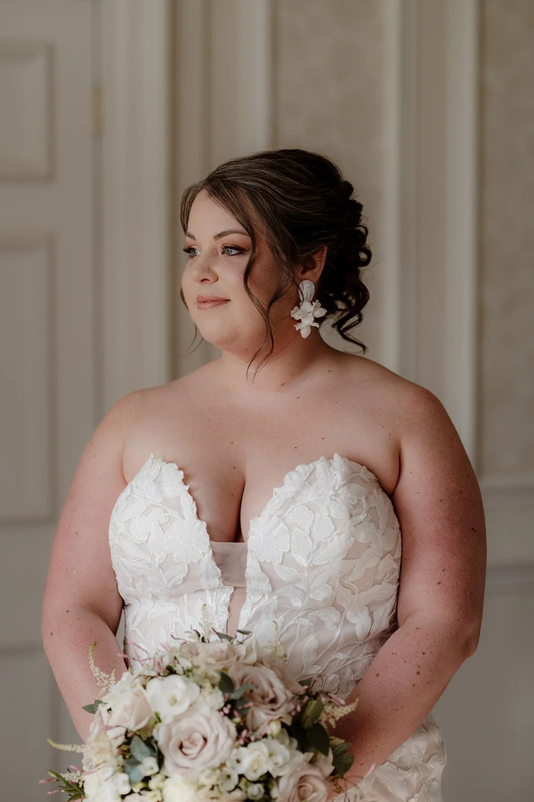 a bride on her wedding day wears a white wedding dress and hold her bridal bouquet