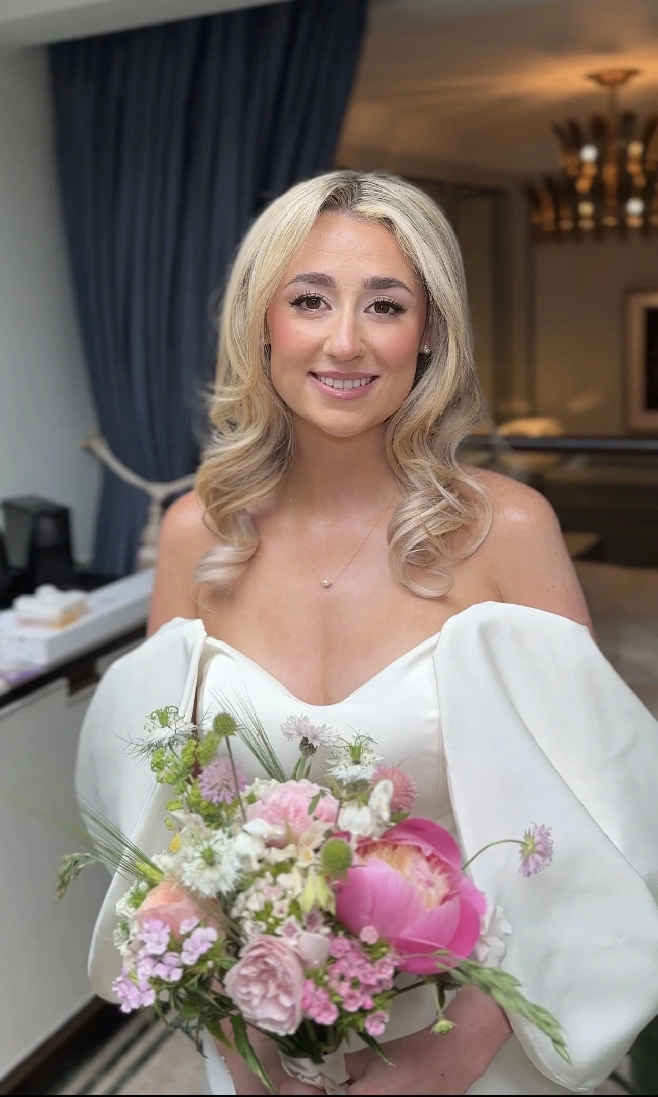 A bride on her wedding day in London, wearing natural wedding makeup and soft glam waves