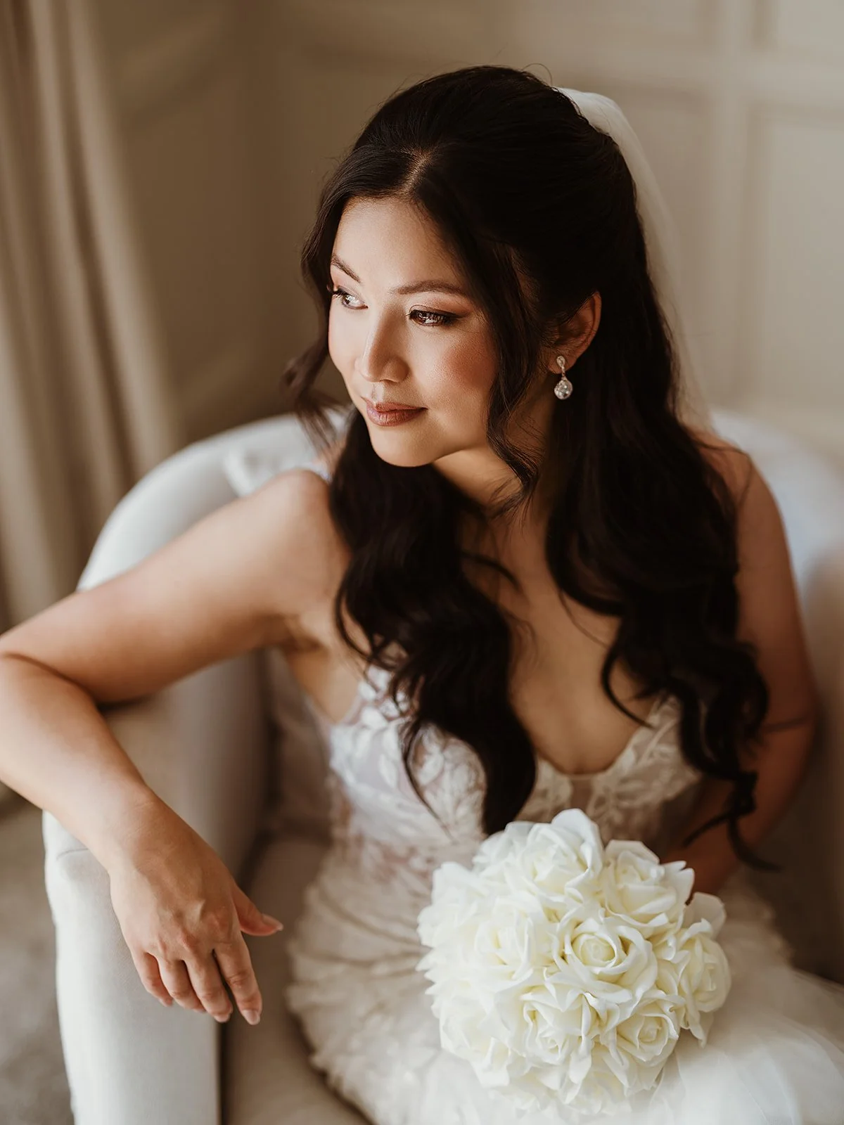 an image of a bride on her wedding day, wearing soft glam makeup and romantic waves