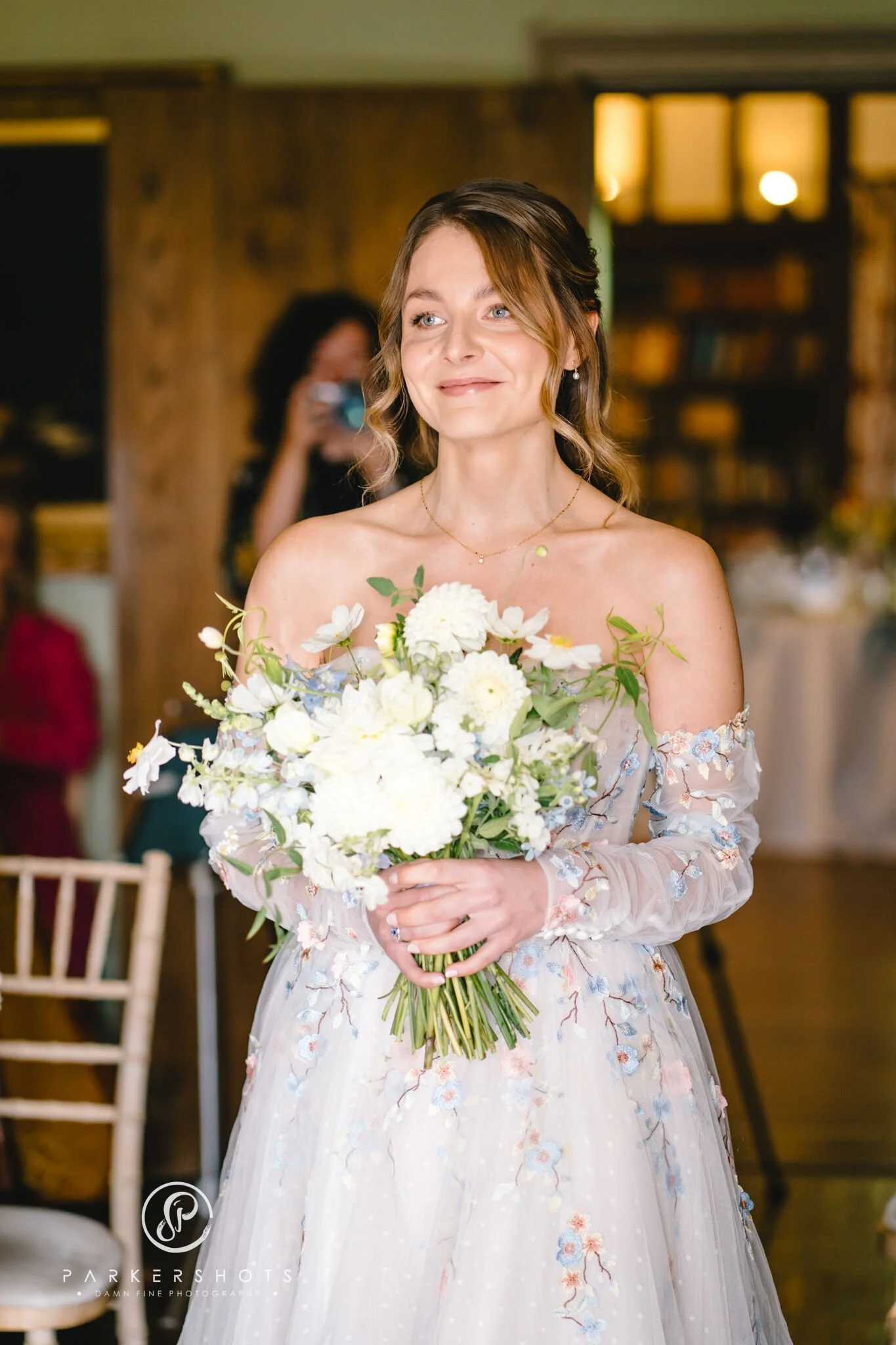 Brides walking down the aisle, smiling and holding flowers