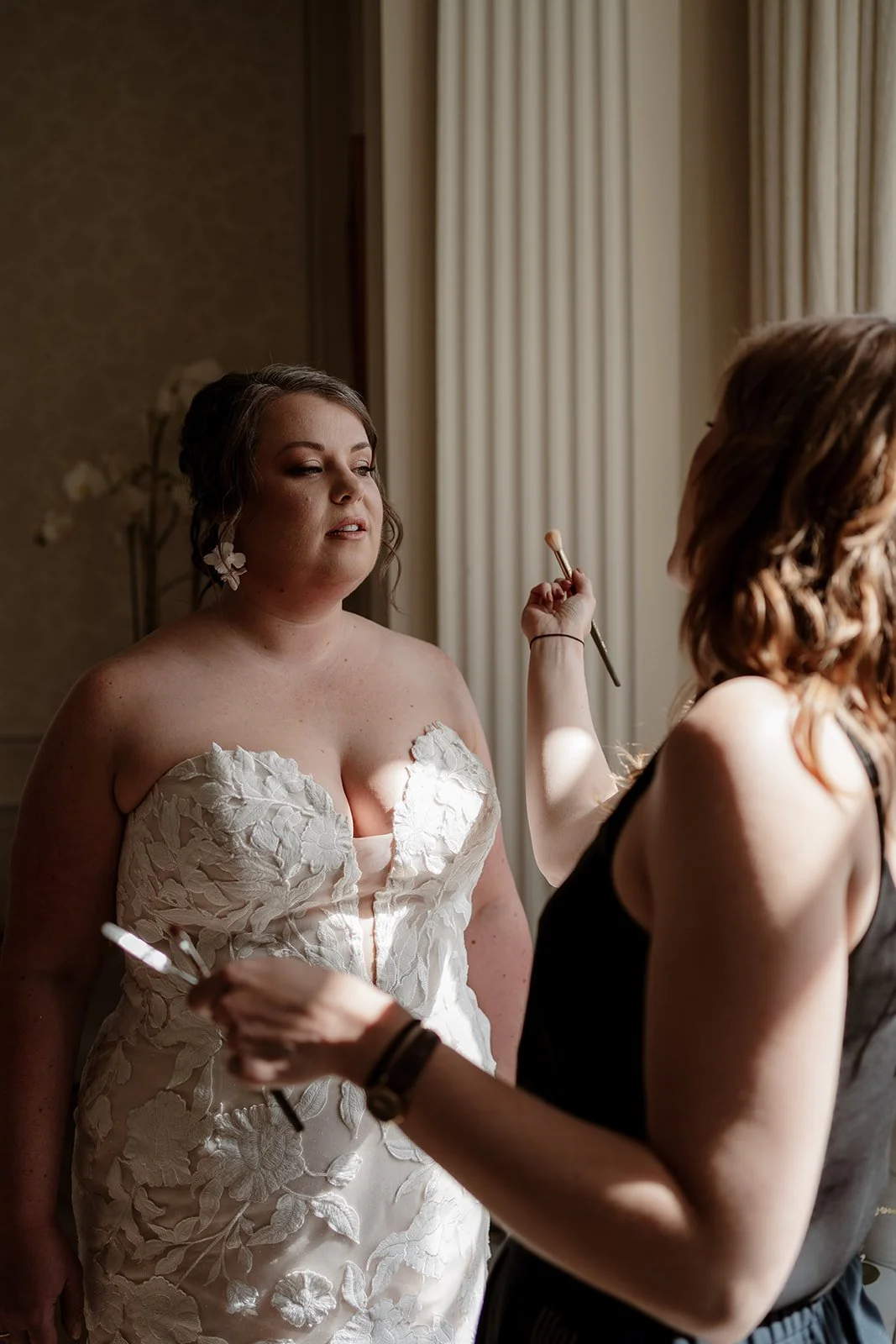 bride on her wedding day having her final makeup touch-ups