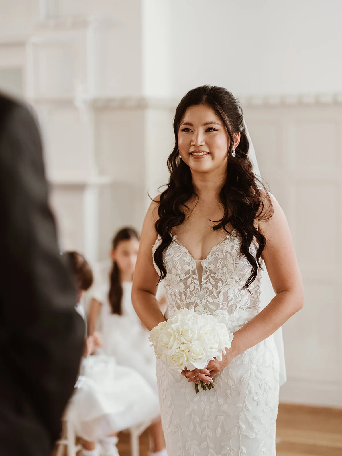 a bride standing at the alter, wearing a white wedding dress and holding a bridal bouquet at Highley Manor wedding venue