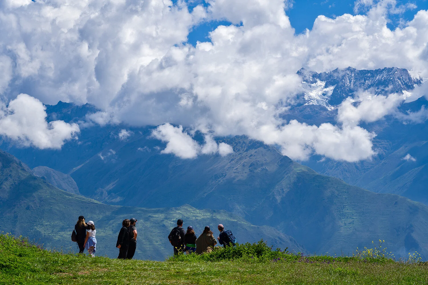  Tourists in Sacred Valley of Peru gaze at distant glacier in Andes near Moray. 