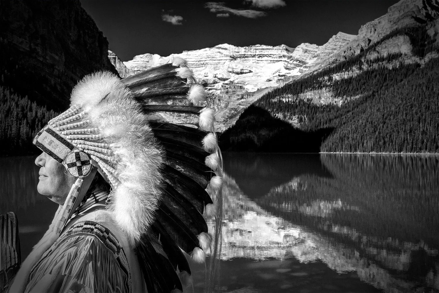  Profile of Cree Chief with headdress against Lake Louise and Victoria Glacier in Banff National Park. 