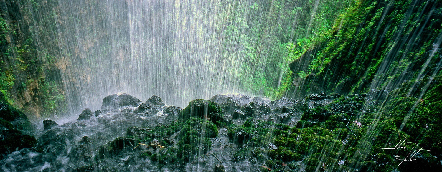  Panorama behind Kapaloa Falls in Pololu Valley on Hawai'i Island. Water cascades from 300 feet above to 200 feet below. 