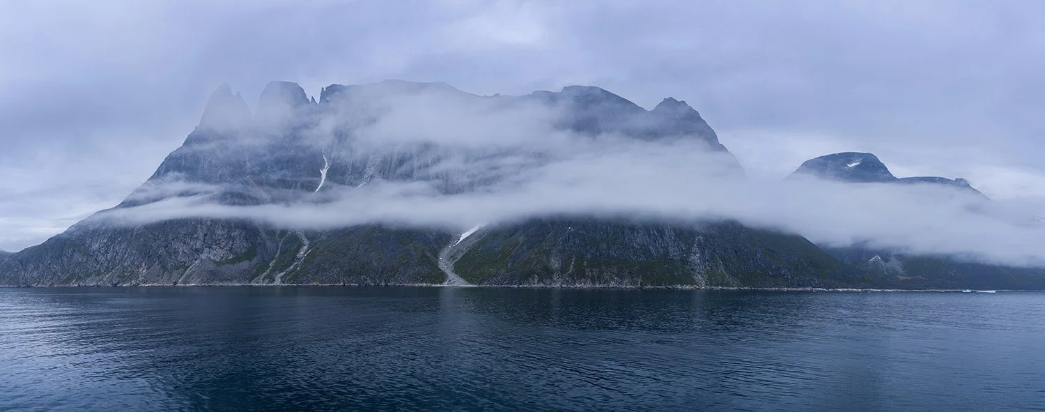 Cloud shrouded mountain panorama near Uunartoq Island in Southern Greenland