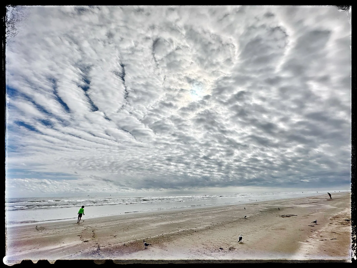 Clouds and contrasting figures on Mustang Island, Texas