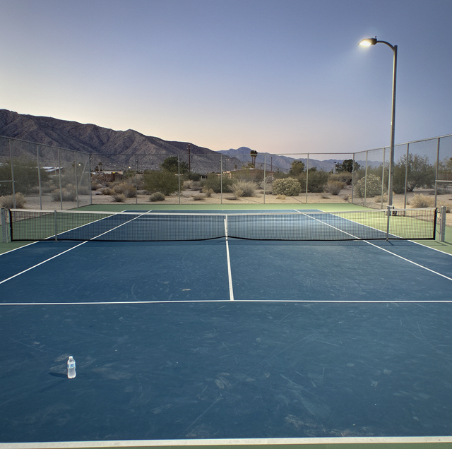 evening tennis court glowing under bright LED lights