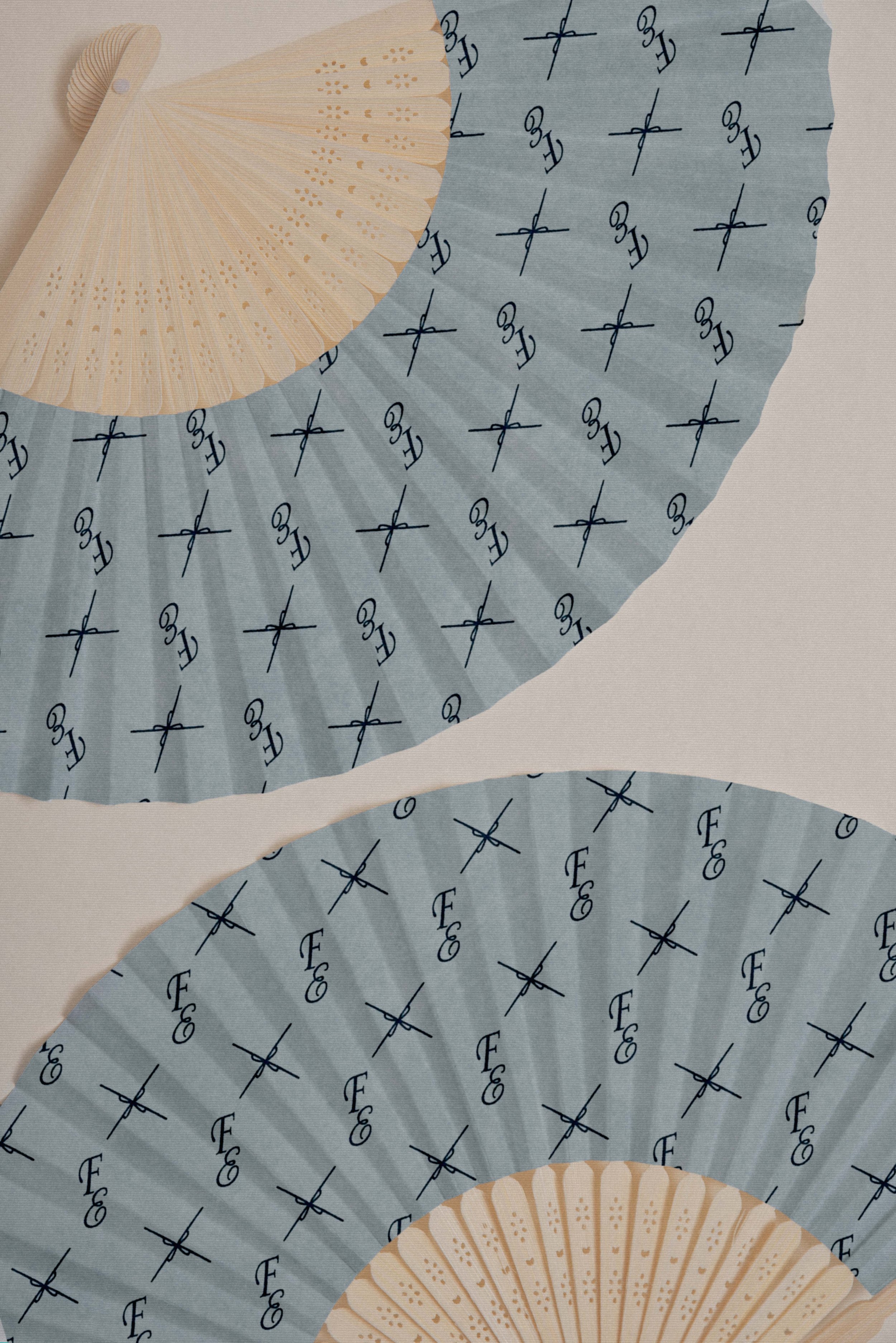 Two blue folding fans featuring a custom typographic pattern.