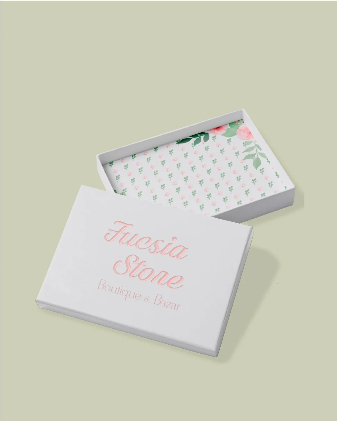 White box with open lid showing "Fuchsia Stone Boutique & Press" in pink script, floral interior pattern
