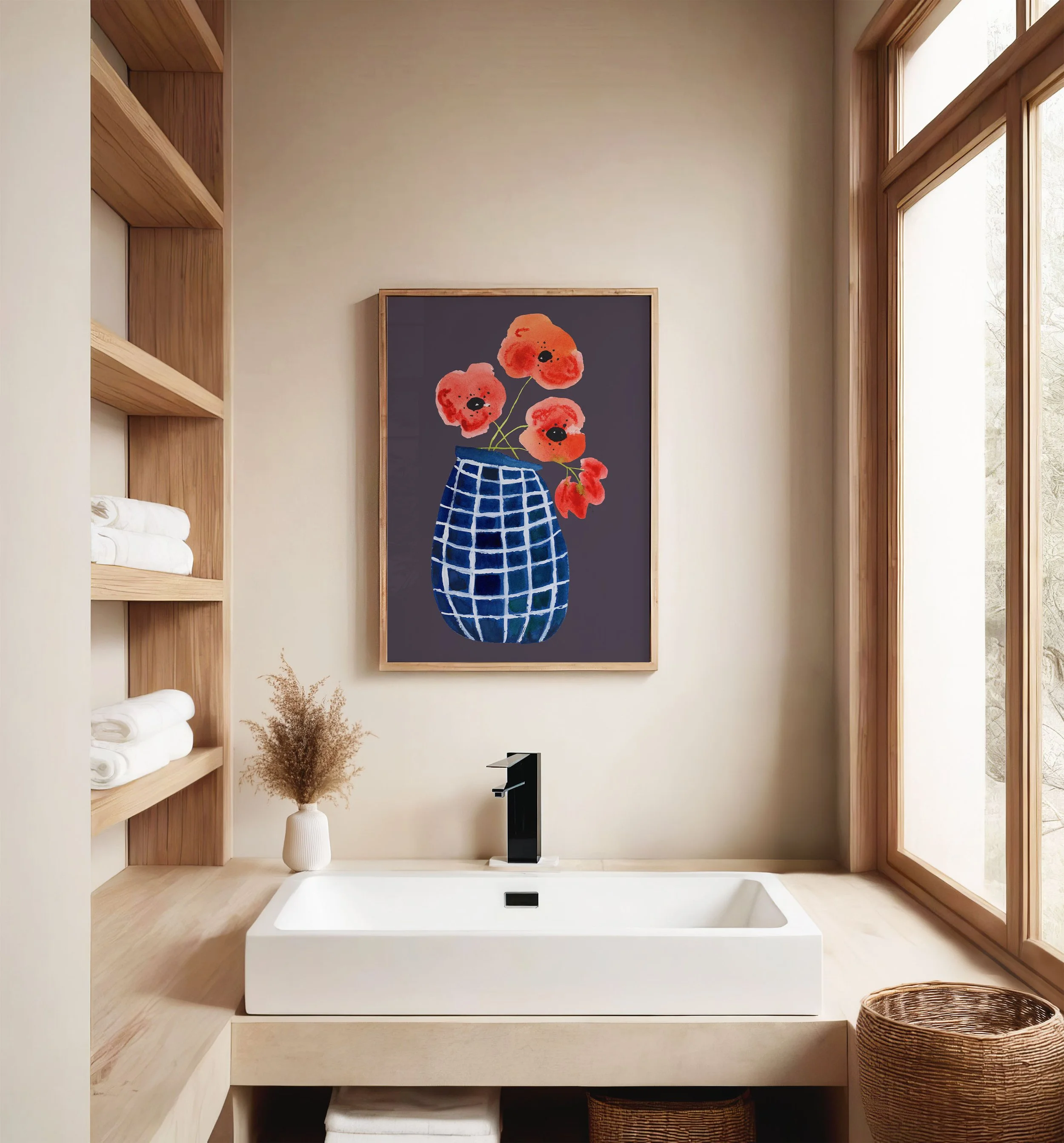 A modern bathroom with a wooden shelf holding towels, a white vase with dried flowers, a rectangular white sink with a black faucet, a framed colorful painting of flowers in a blue vase, and a large window with wooden framing providing natural light.