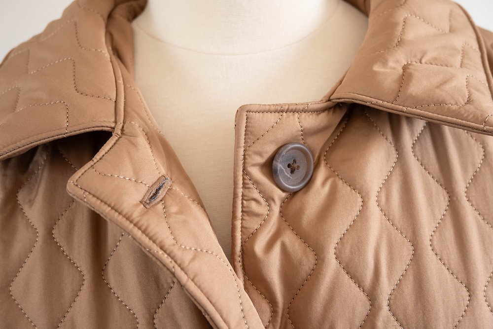 Biscuit coloured quilted coat, close up of the buttons