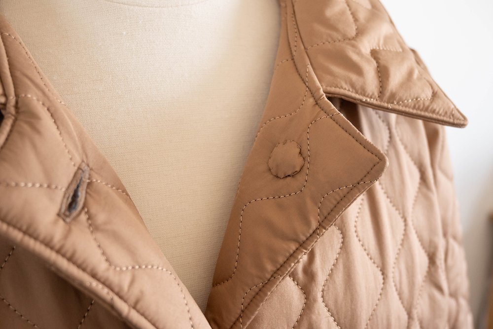 Biscuit coloured quilted coat, close up of the buttons
