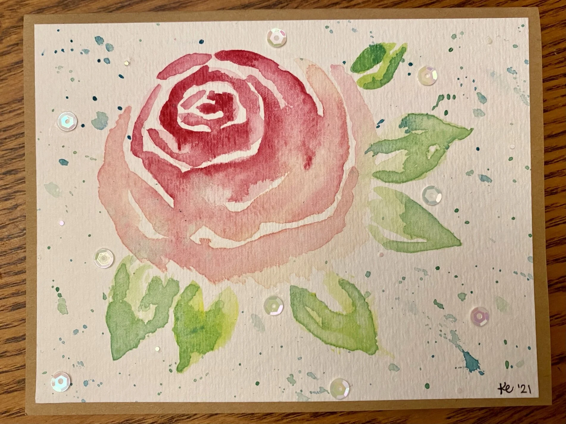 A custom birthday card featuring a watercolor rose and sequins