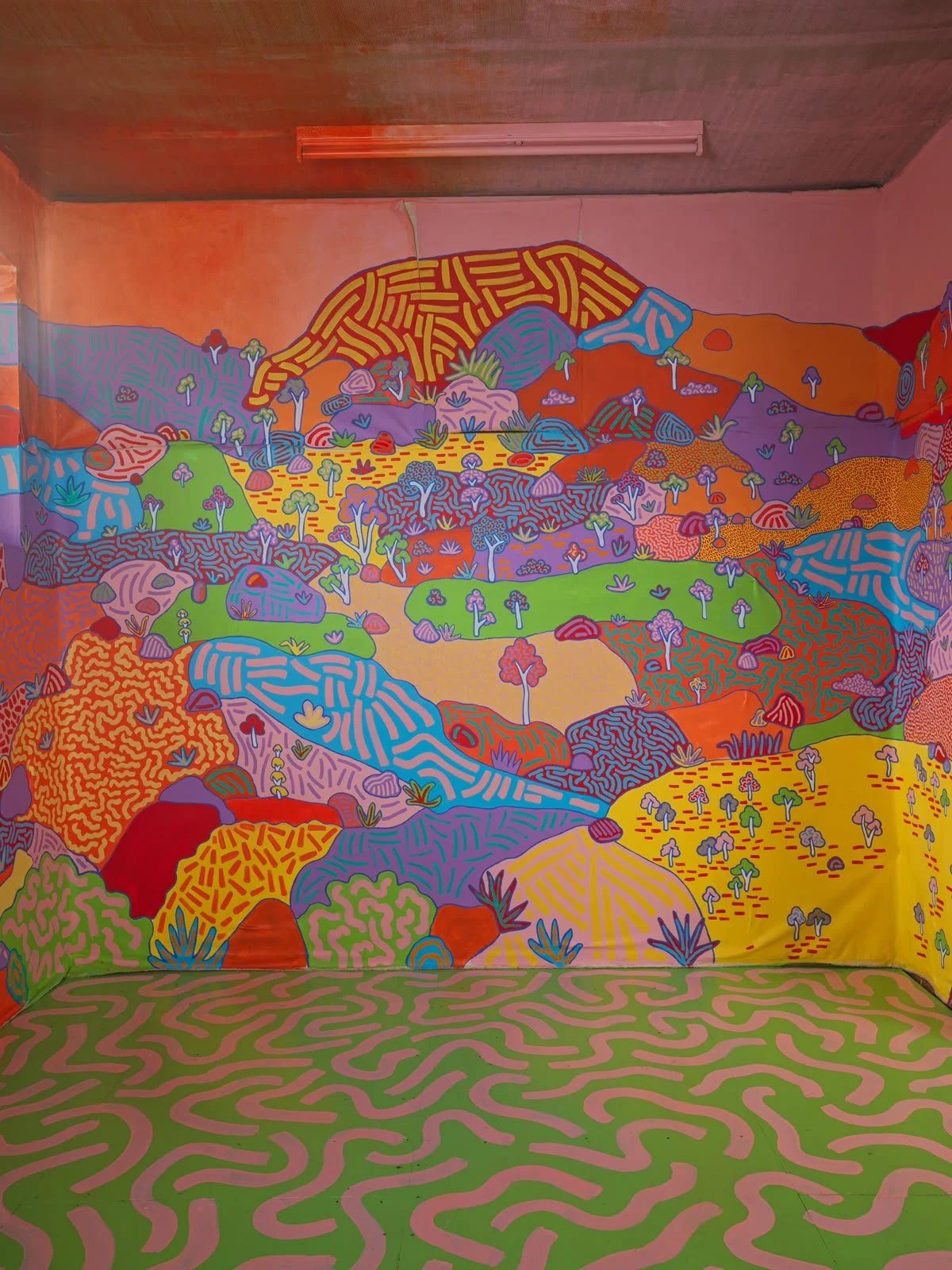 Detailed landscape mural by Kat Tillman featuring rolling hills, native plants, colourful trees and imaginative Australian scenery painted across the walls of a Warrandyte house.