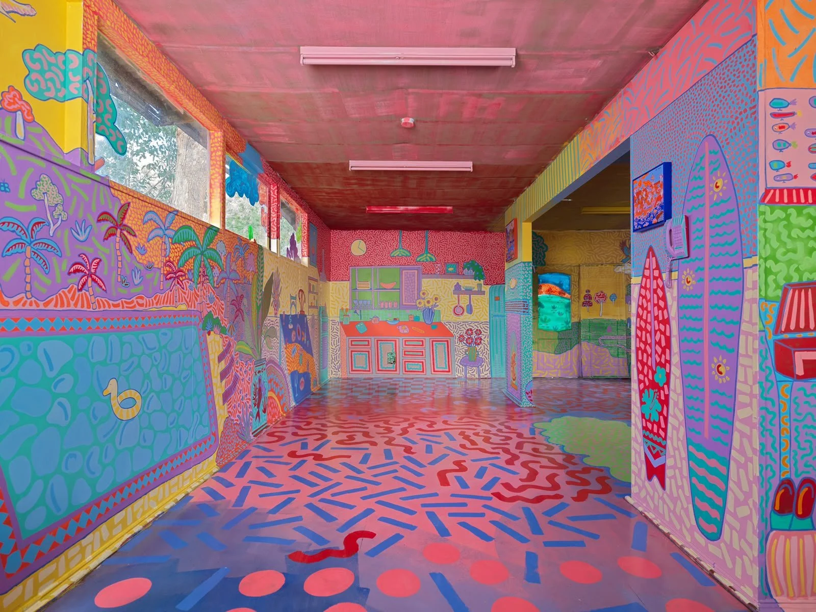 Detailed illustrated mural of colourful houses nestled among trees and rolling hills, painted by Kat Tillman as part of the Side Quest Stories immersive art installation.