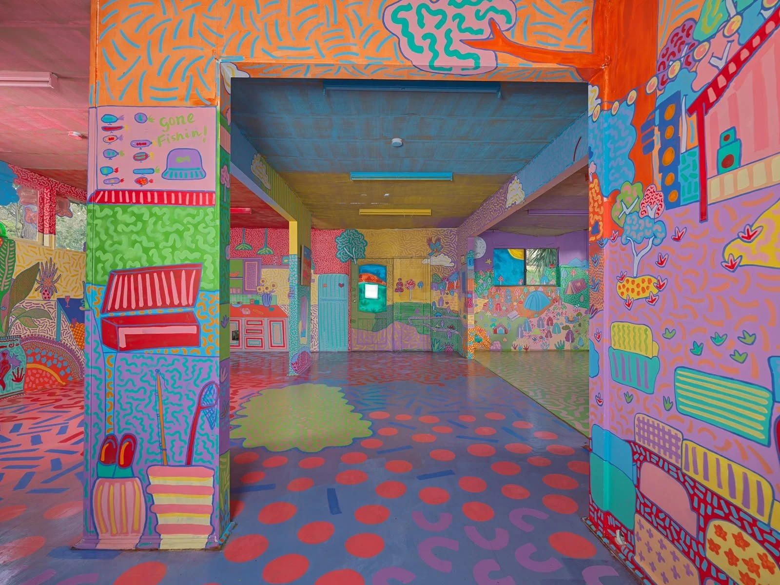 Vibrant interior of the Side Quest Stories art installation in Warrandyte, showcasing hand-painted walls, colourful architectural details and playful patterned flooring.