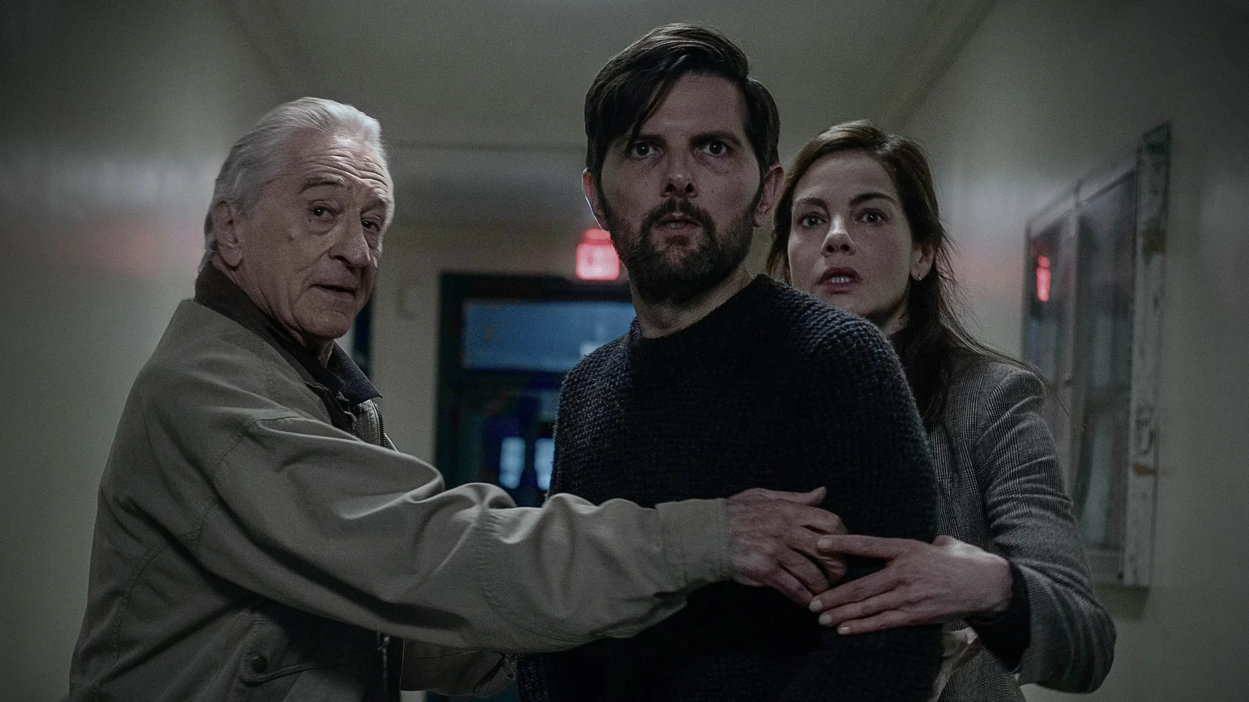 Robert De Niro, Adam Scott and Michelle Monaghan react to a tense moment in The Whisper Man (2026).
