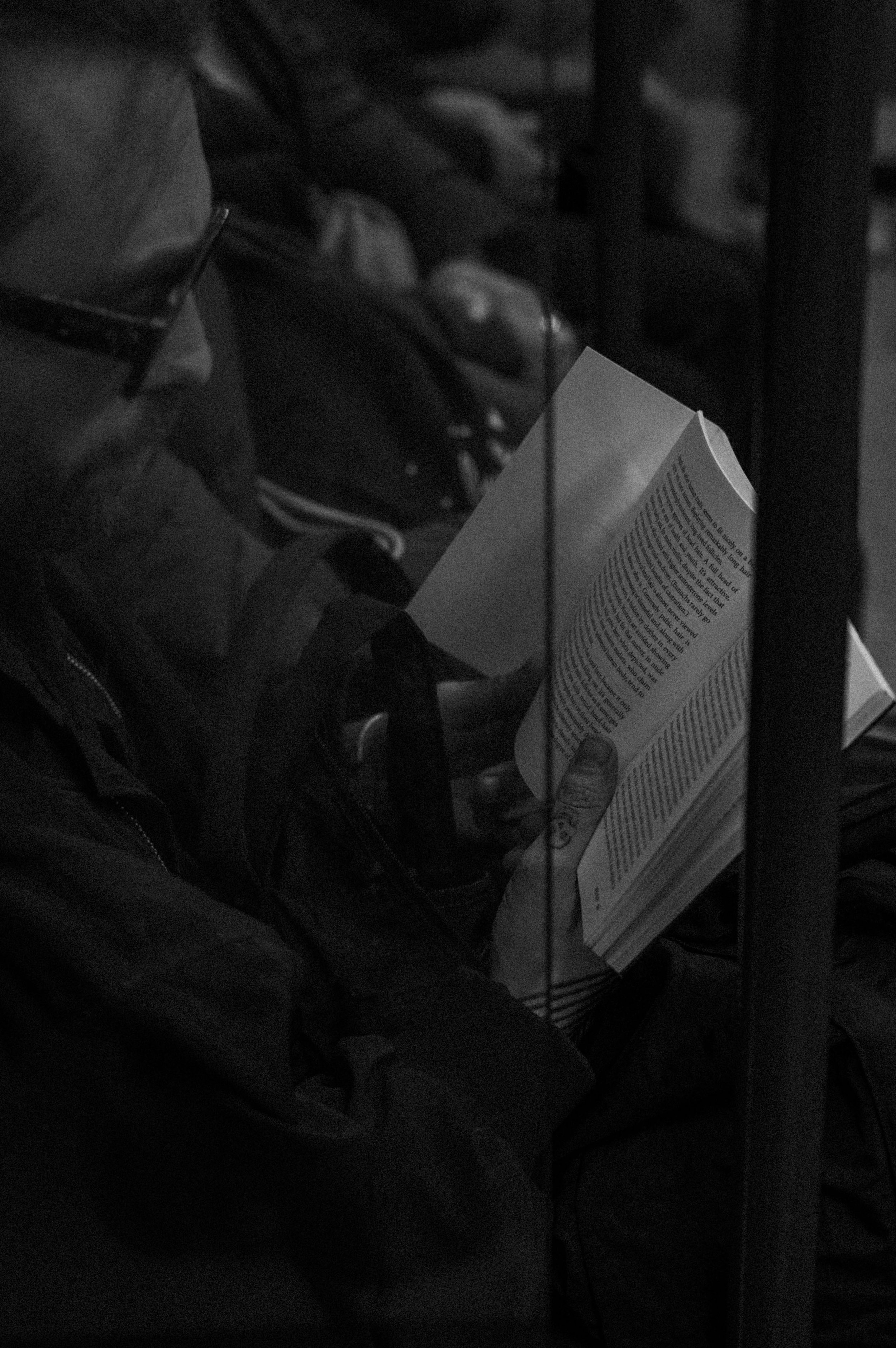 Mann mit Brille liest Buch in Londoner U-Bahn Tube