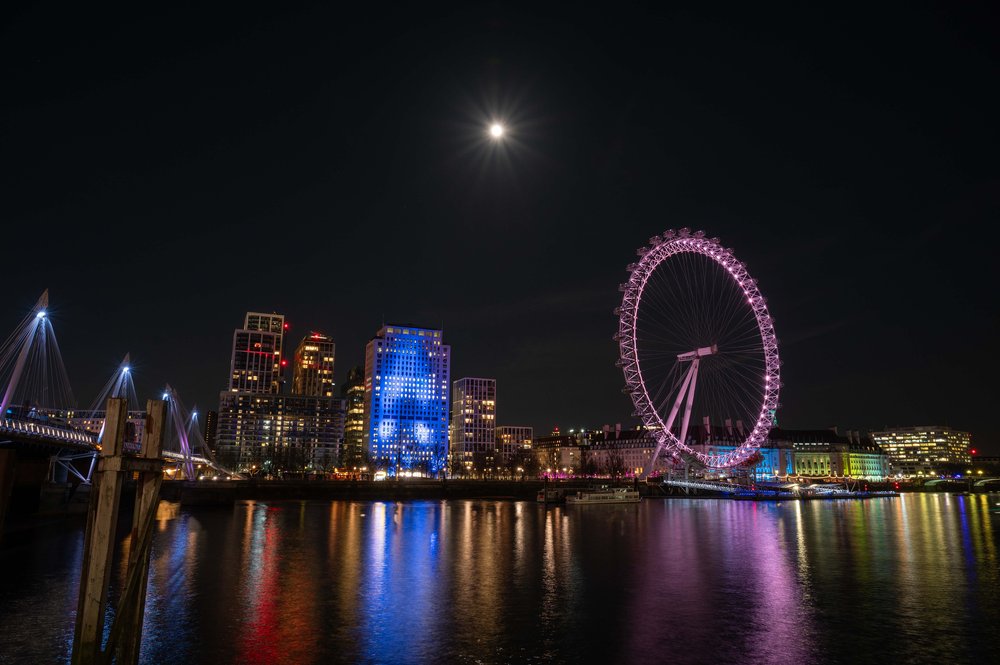 London bei Nacht - London Eye mit spiegelnder Themse und Mond