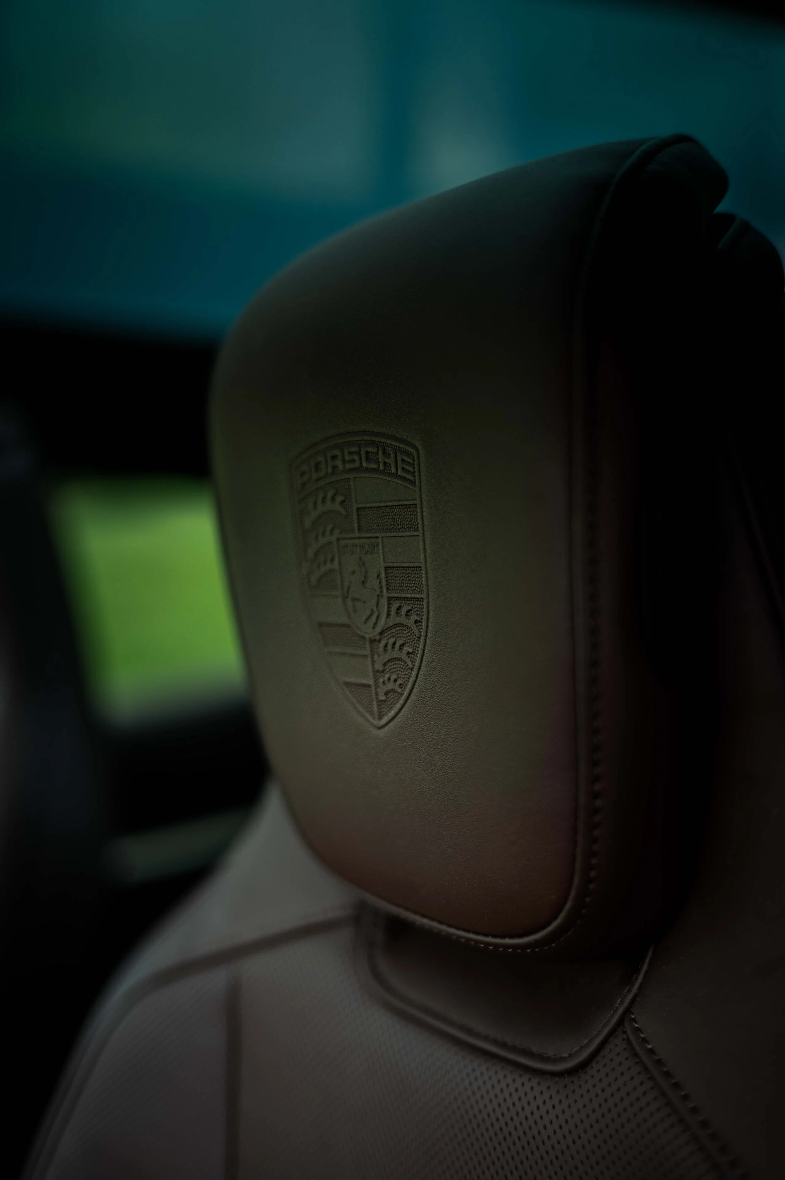 Das eingenähte Porsche Logo auf dem Fahrersitz des Taycan 4S