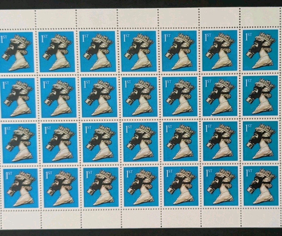 Close up of the blue queen Elizabeth the 2nd stamps wearing a gasmask