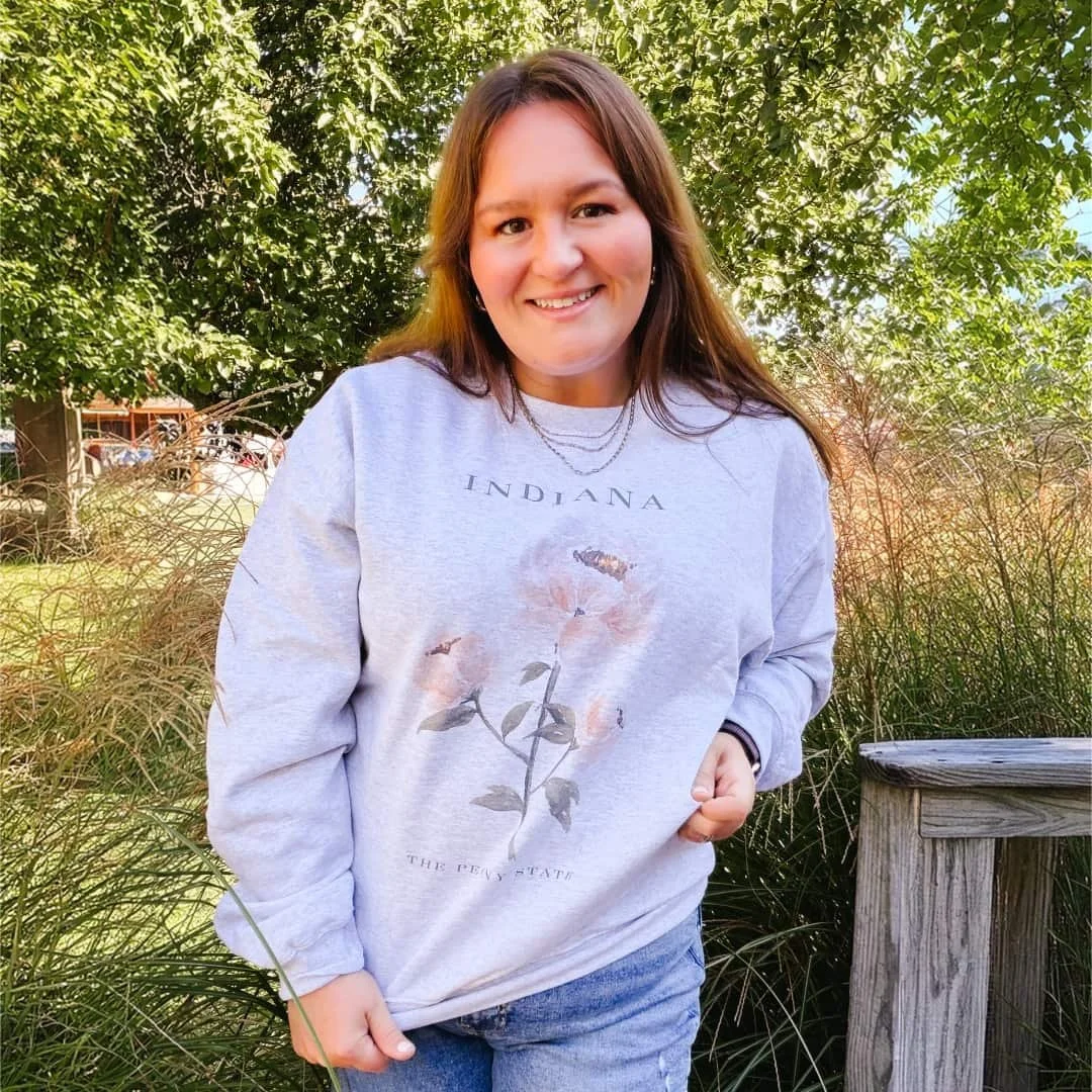 Woman outdoors wearing the Pink Peony watercolor Indiana crewneck sweatshirt