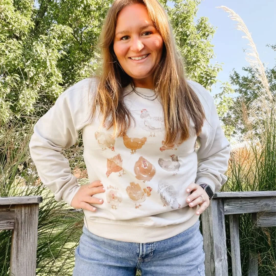 Woman outdoors wearing the Chickens watercolor farmhouse crewneck sweatshirt