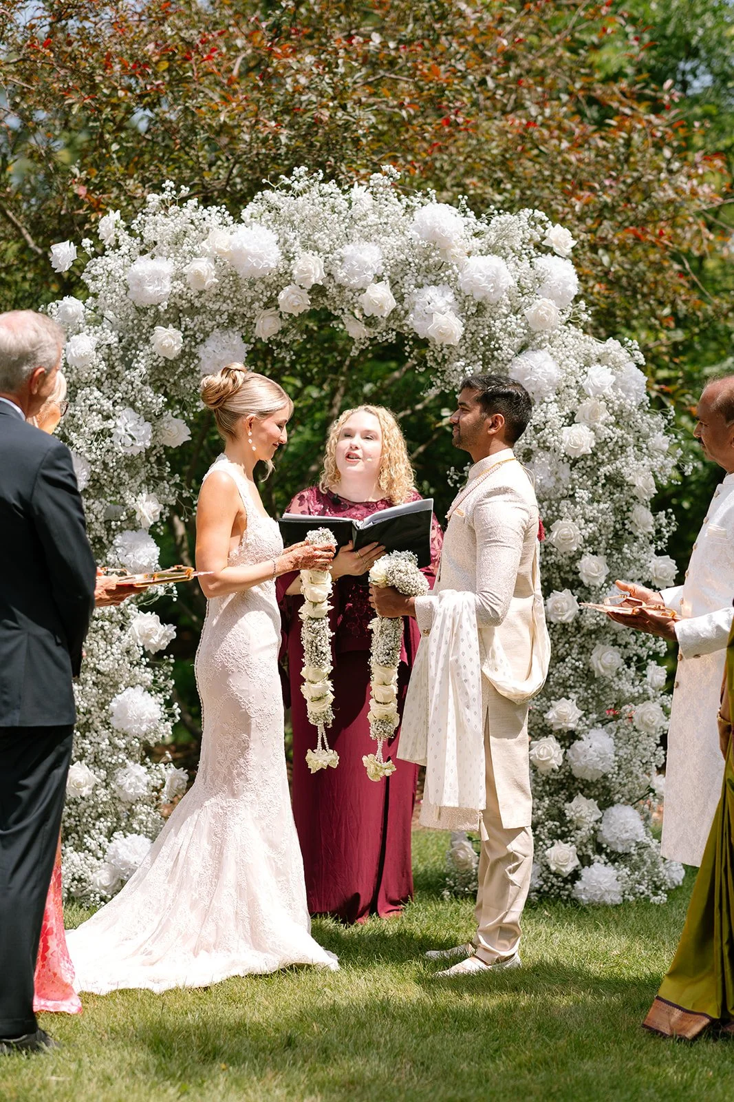 Bride and groom exchanging garlands during the Varmala or Jaimala in and Indian fusion ceremony with Chicago wedding officiant Carla Doshi Forever Incredible.