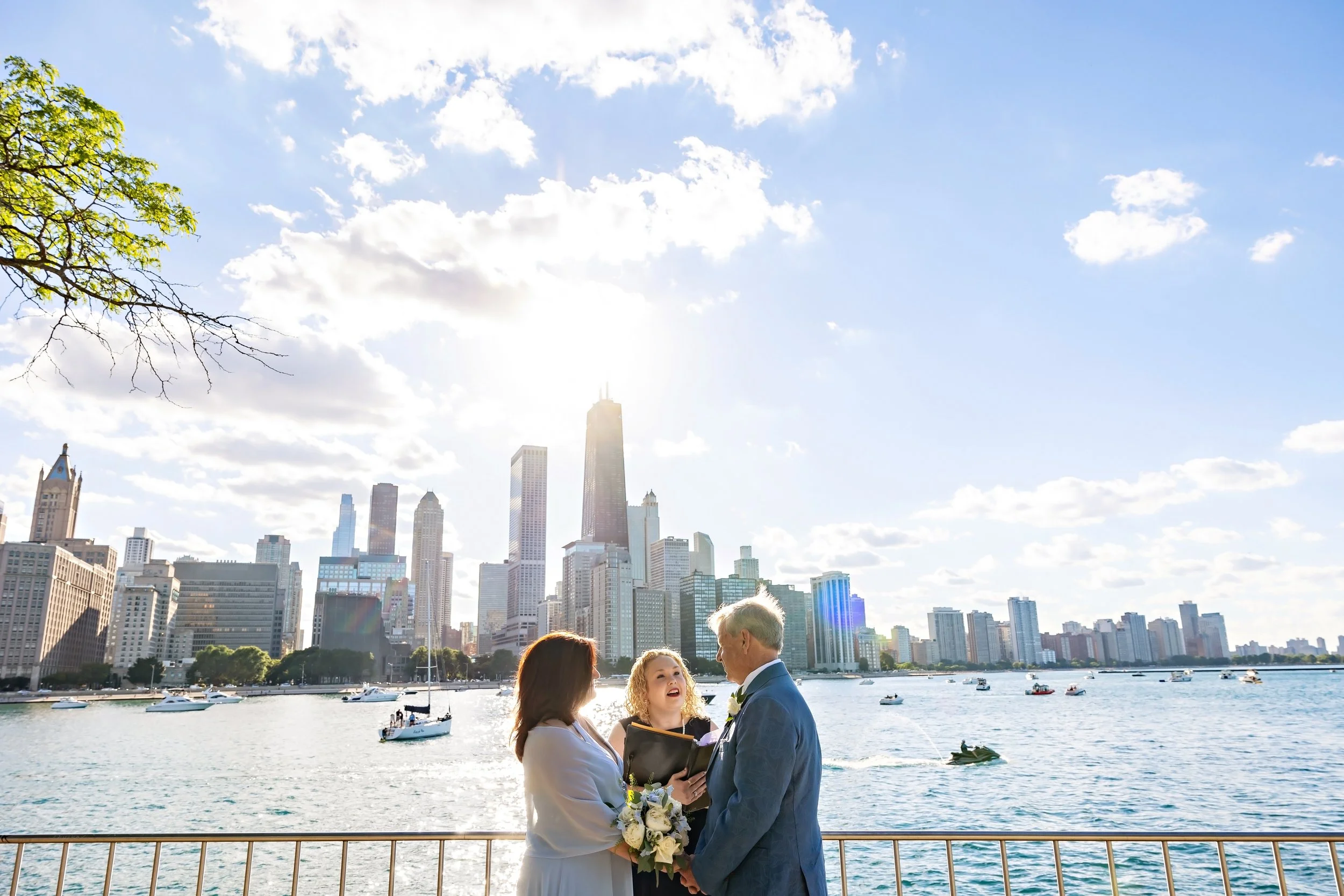 Couple stands at Olive Park with the Chicago skyline in the background for their intimate summer elopement.  Photo by Elope to Chicago