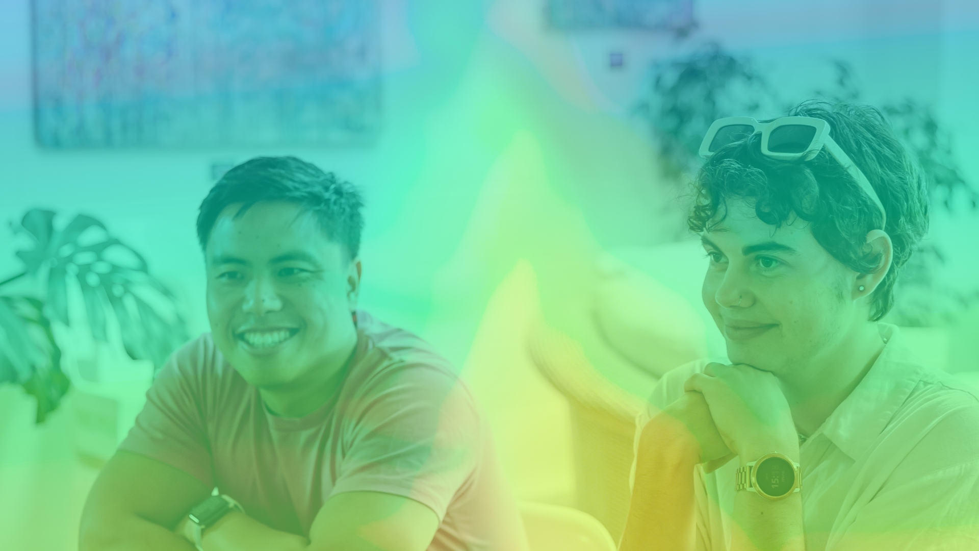 A picture of two people smiling and looking off camera, with a rainbow overlay on the whole image