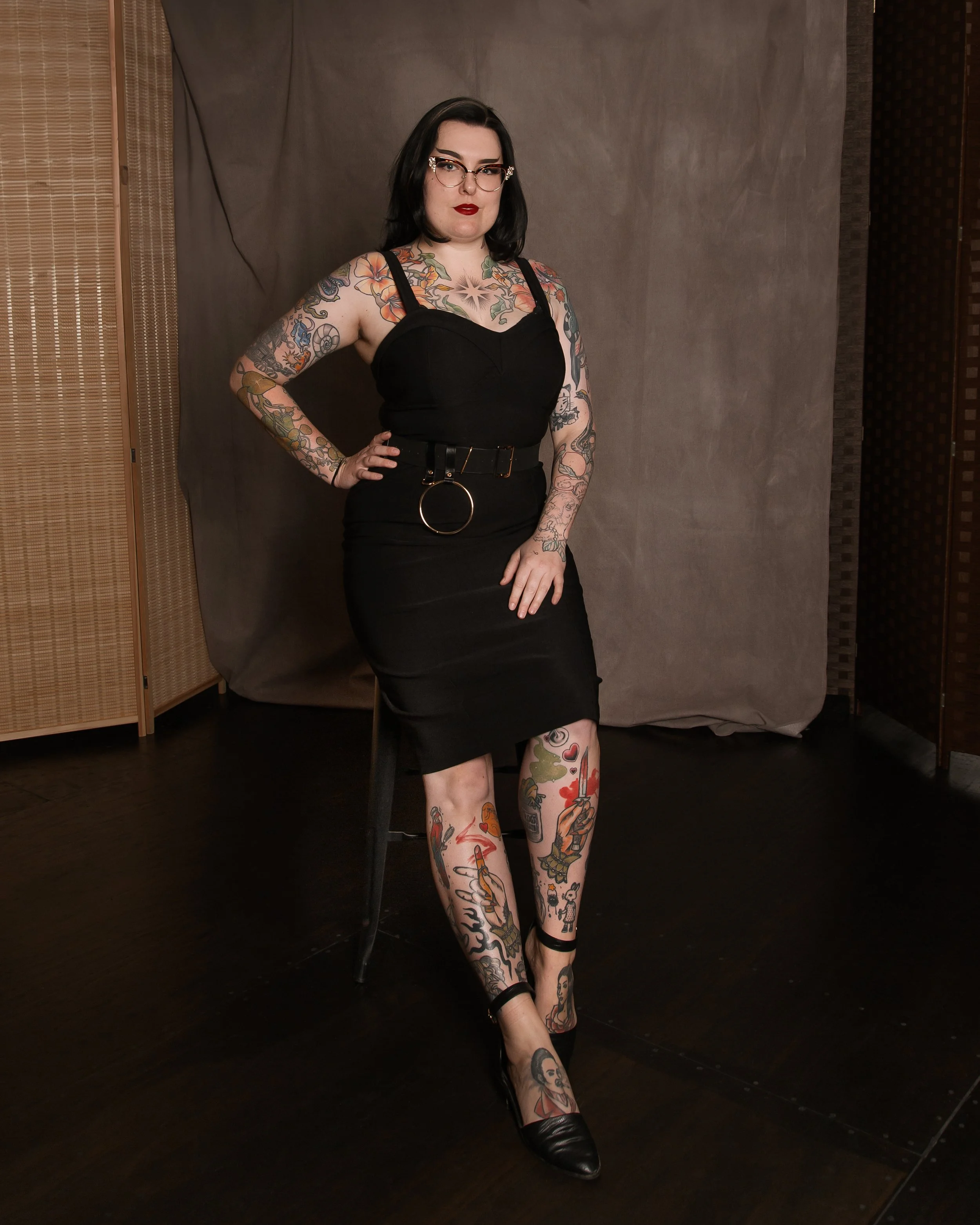 Jamie Renee, a tattooed woman in a 1950s pin-up style dress and pose