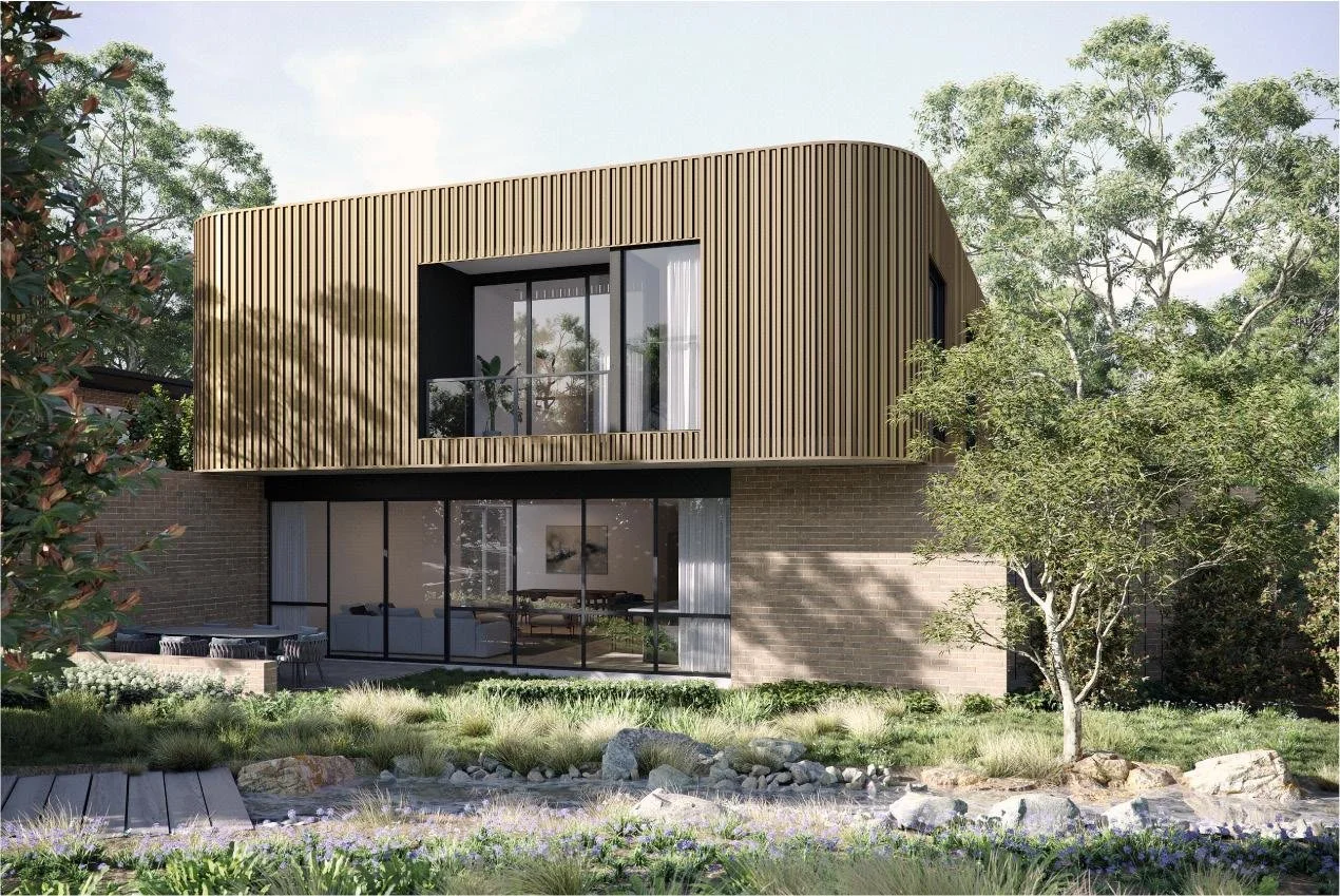 Modern two-story house with brown beige exterior, wooden accents, and large windows. Front garden with plants and steps leading to the entrance. A parked car is on the right side of the house.