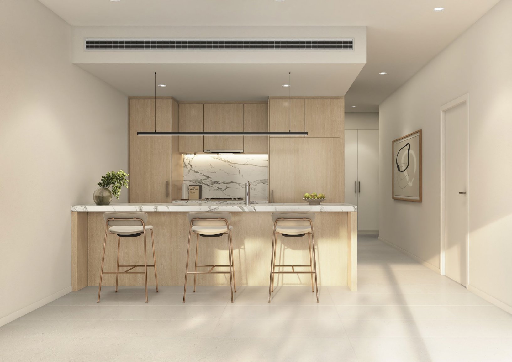Modern kitchen with light wood cabinets, white marble backsplash, and a marble island with three barstools. There's a plant on the left, a bowl of green apples on the right, and artwork on the wall. The kitchen features built-in appliances and minima