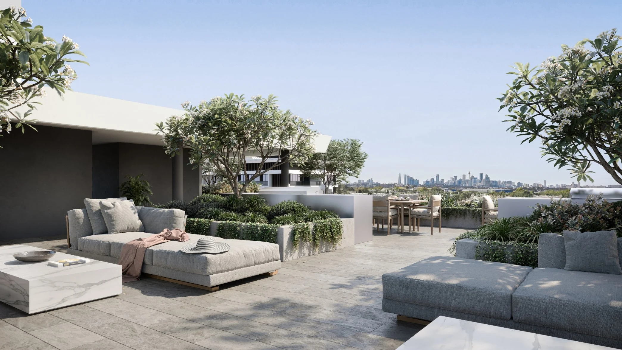 Modern rooftop patio with outdoor furniture, including a sectional sofa with pillows, a coffee table, and dining table with chairs. There are trees, plants, and city skyline in the background under a clear blue sky.
