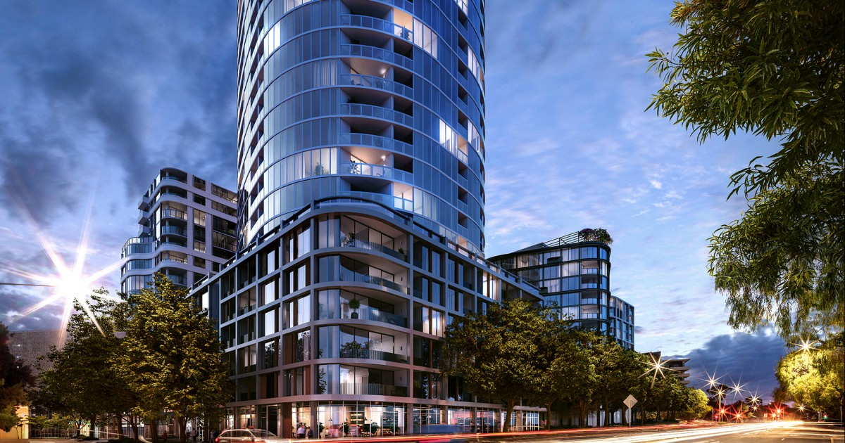 Modern high-rise residential building with curved glass balconies, surrounded by trees, with a sunset sky in the background.