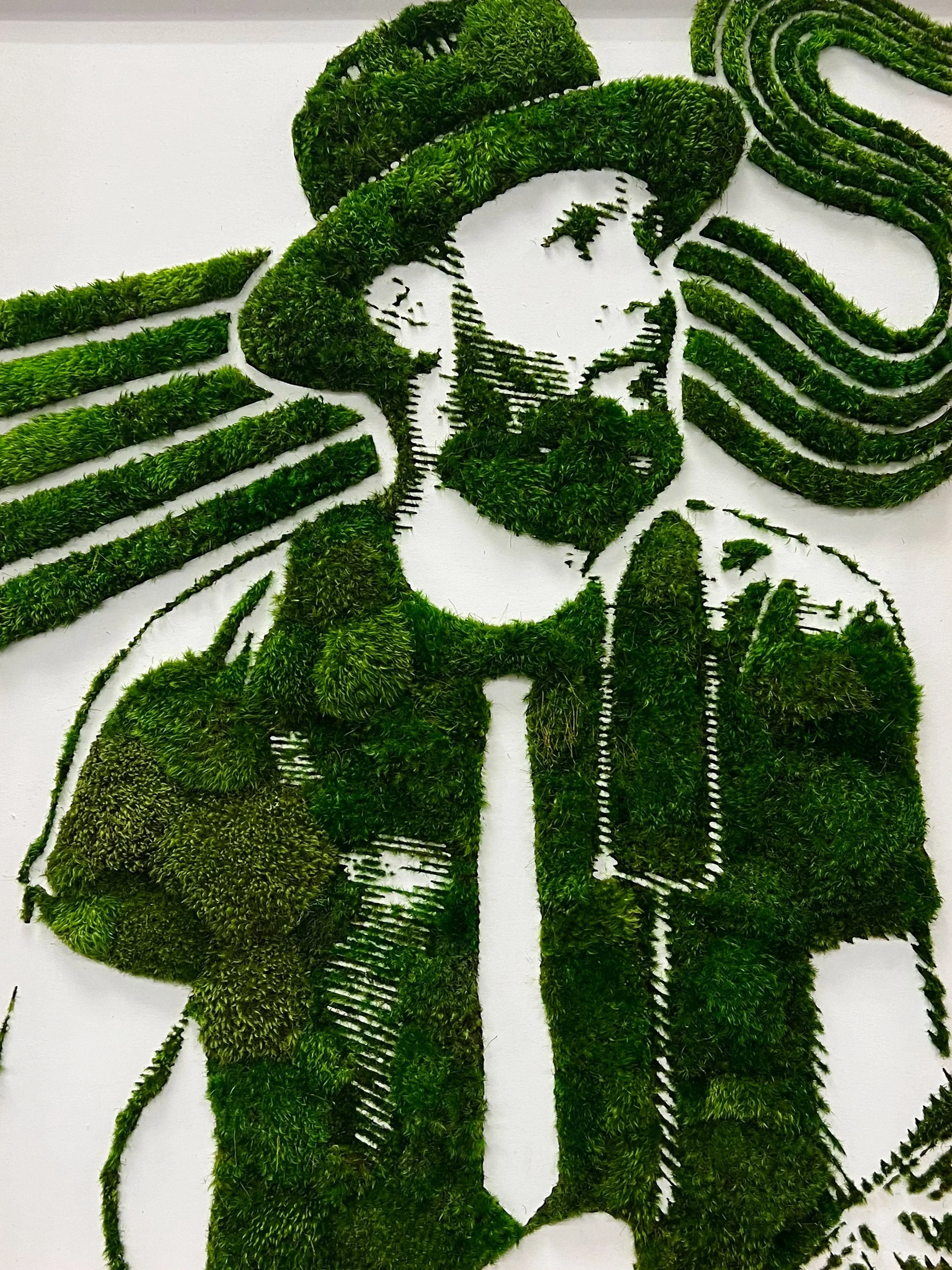 A green moss wall art piece depicting a famous musician on a white background.