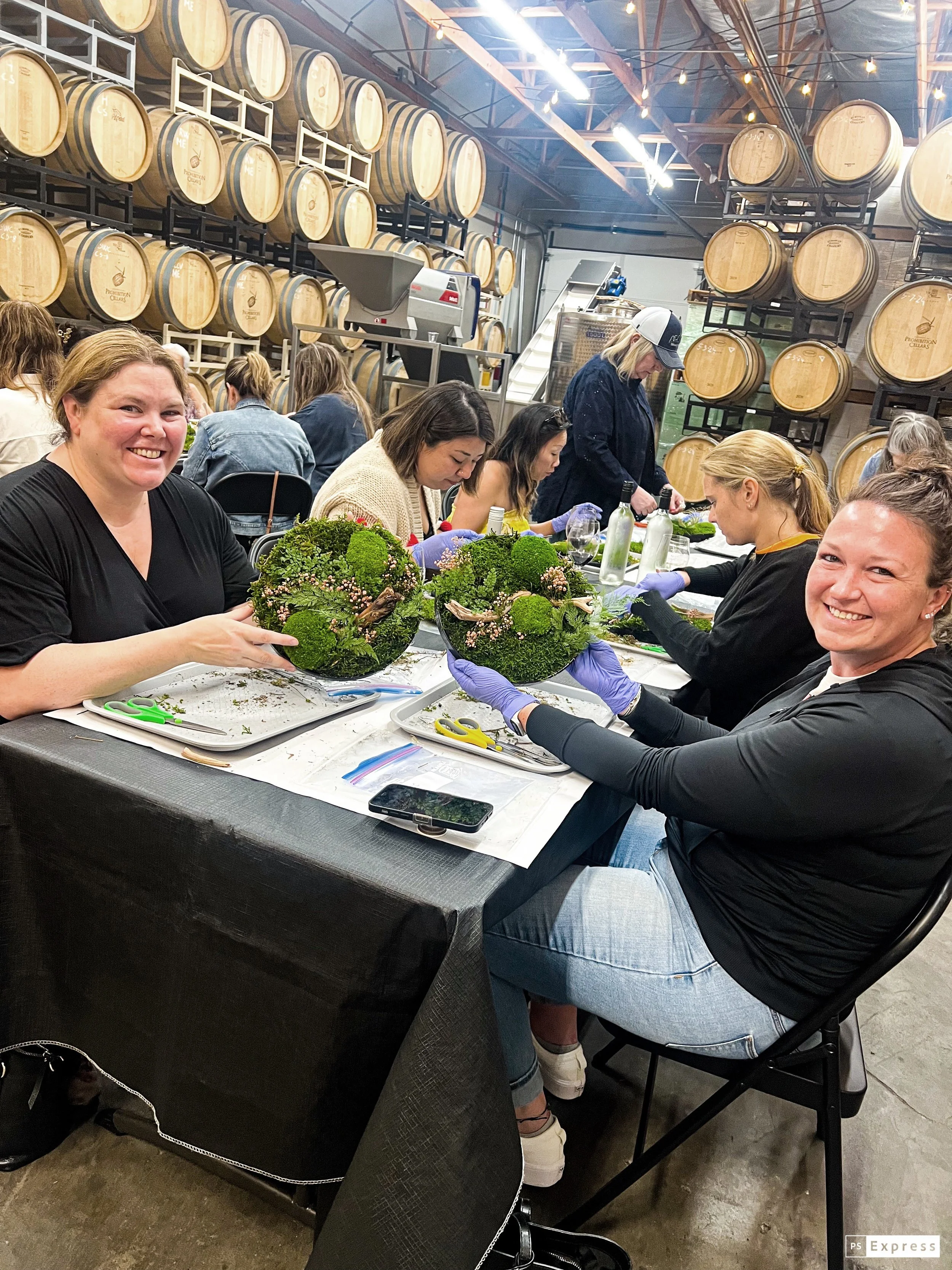 Workshop participants building preserved moss wall art and terrariums with JJ Rose