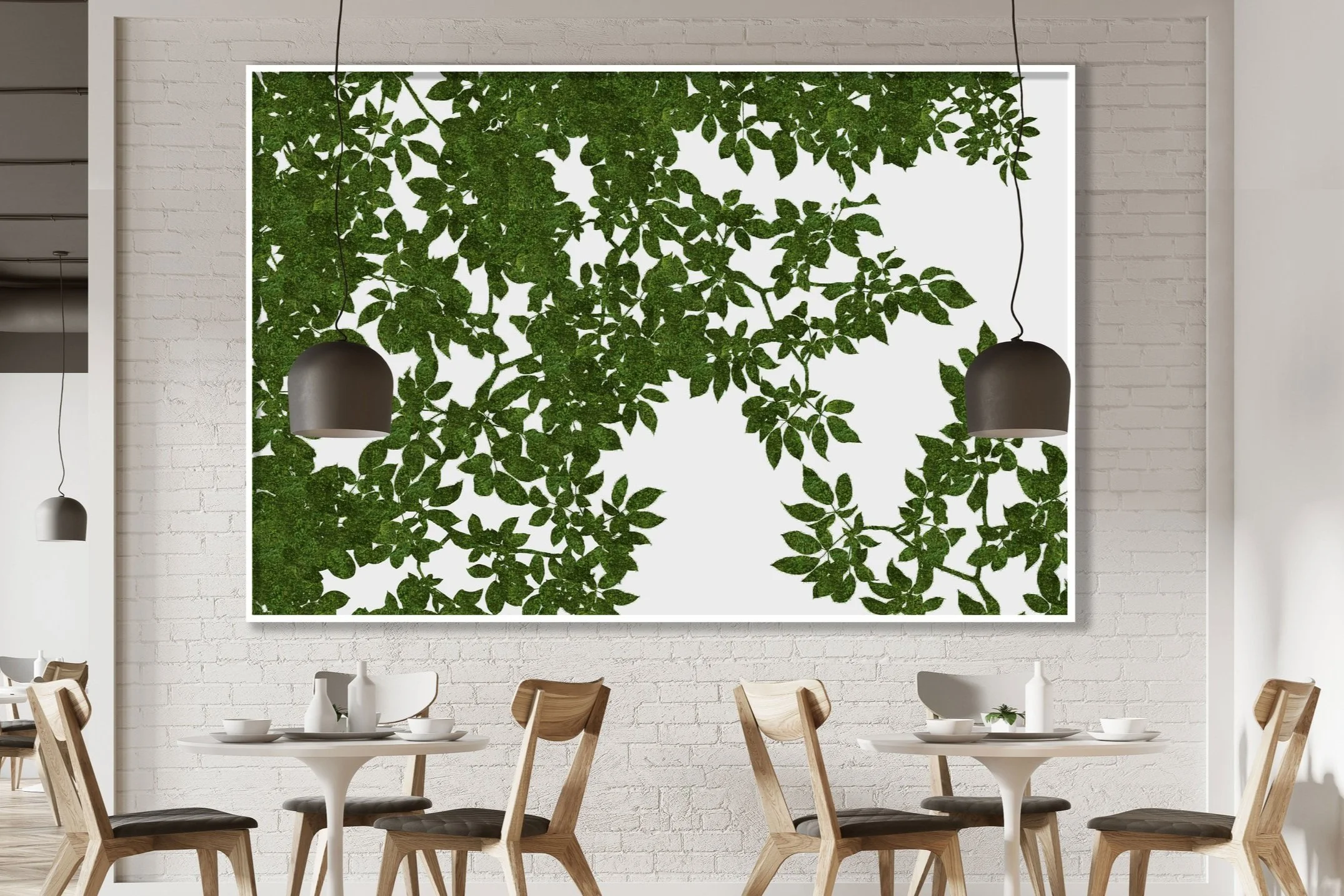 Modern dining area with wooden chairs around white tables, a textured white brick wall, and a large framed green preserved moss leaf-patterned art piece on the wall, illuminated by pendant lights.