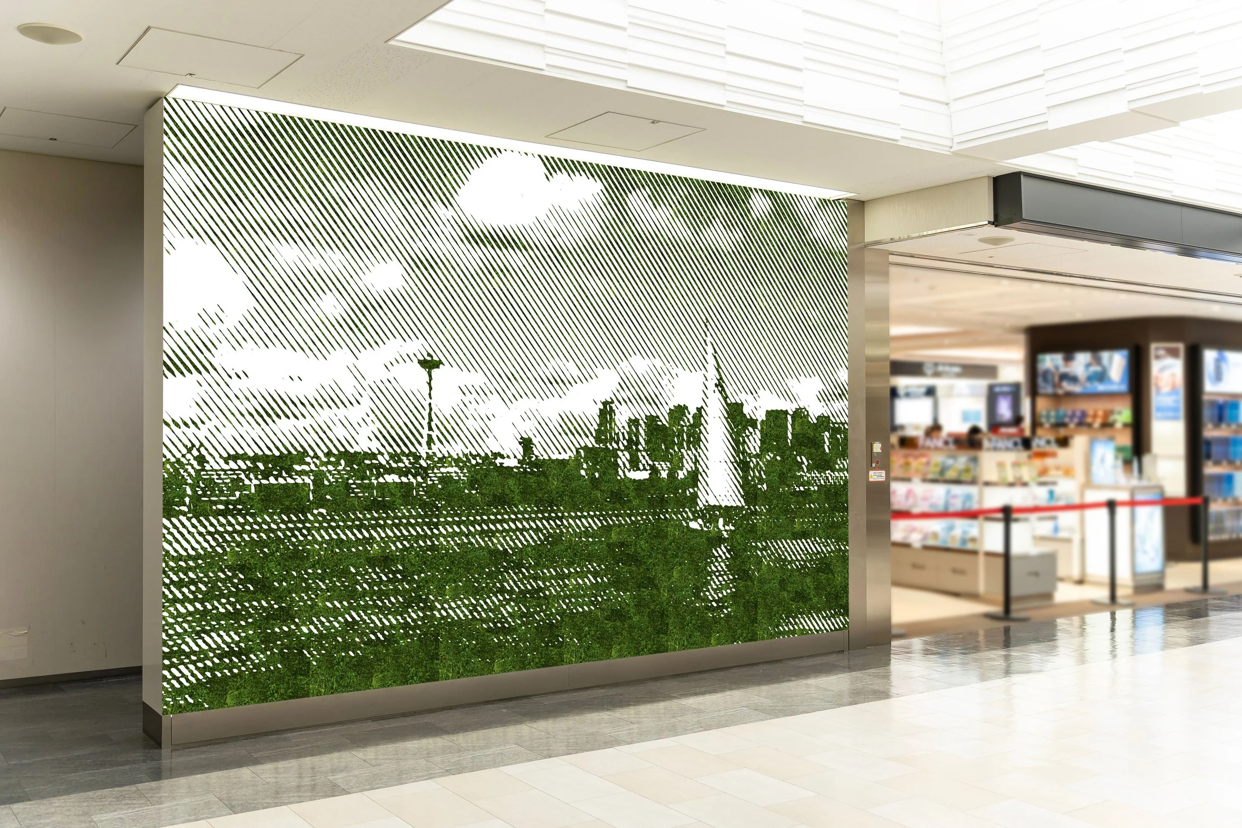 Interior of a shopping mall or airport with a decorative moss wall featuring a cityscape silhouette and clouds, and a book or electronics store visible in the background.