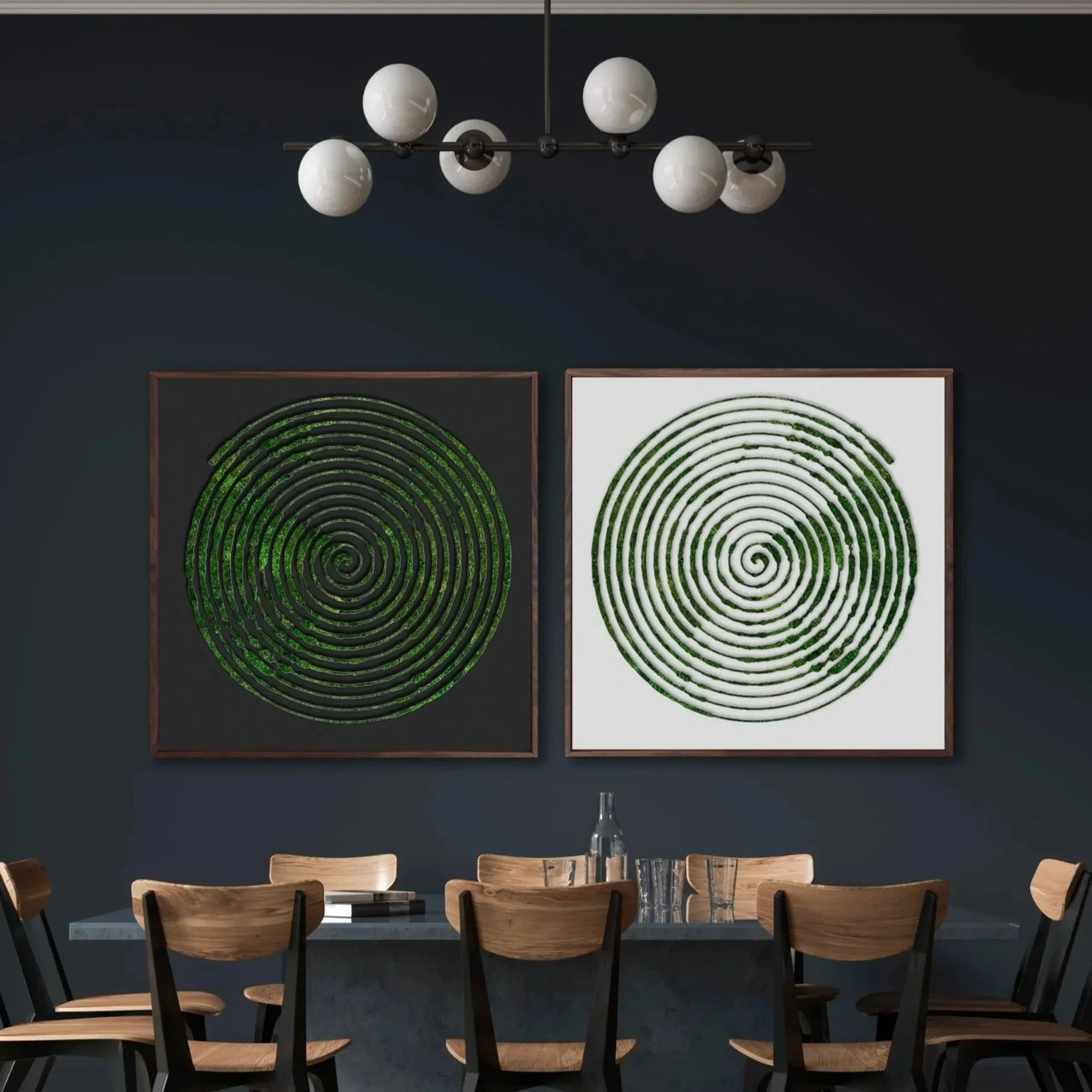 A modern dining room with a dark wall, featuring two framed spiral design moss artworks. There is a wooden table with six matching chairs, a glass bottle, and drinking glasses. A sleek chandelier with six globe lights hangs above the table.