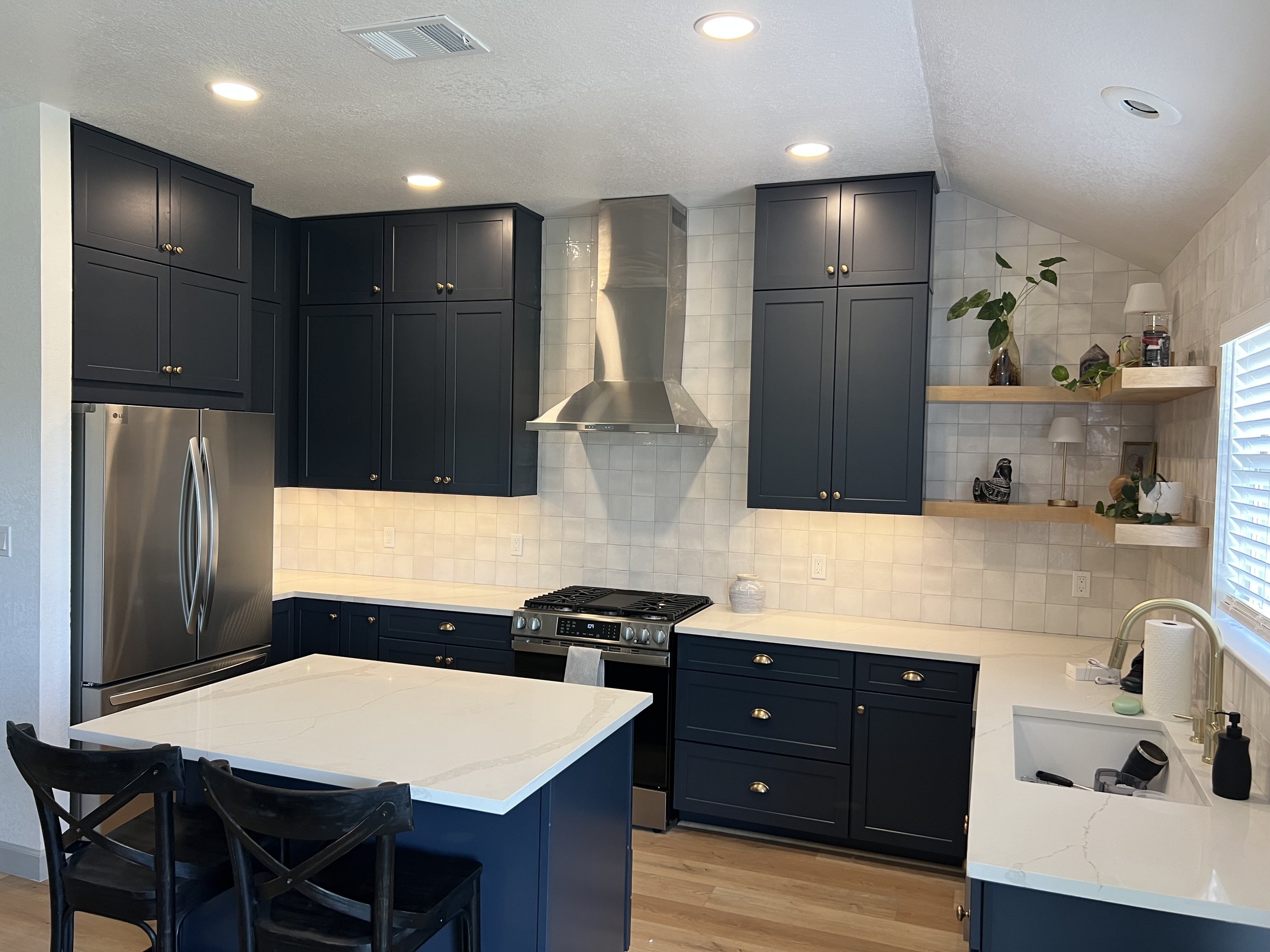 Shaker Navy & Maple Rye floating shelves paired with quartz countertops