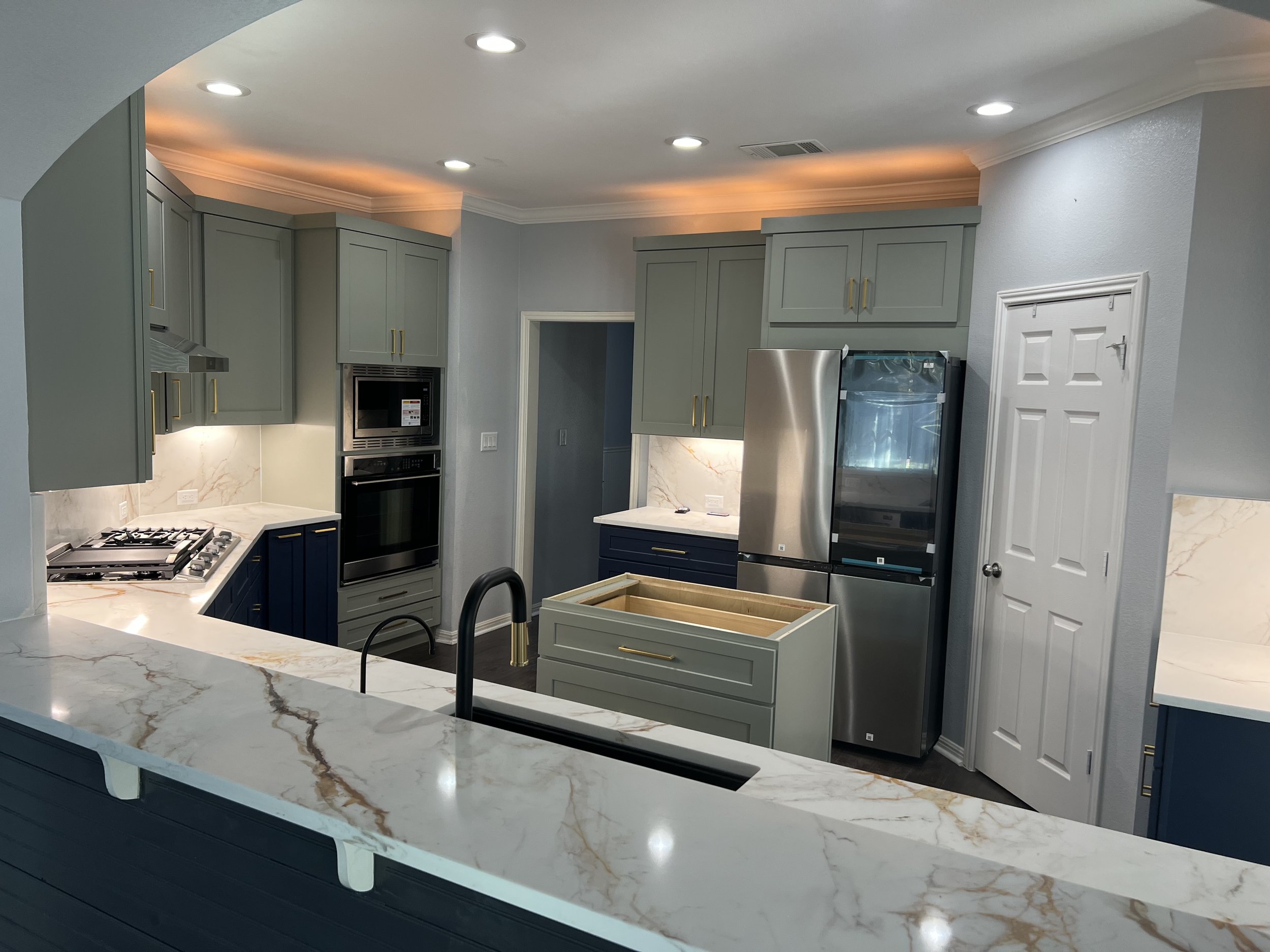 Kitchen Transformation in Round Rock, Texas with Shaker Moss & Shaker Navy paired beautifully with quartzite countertops