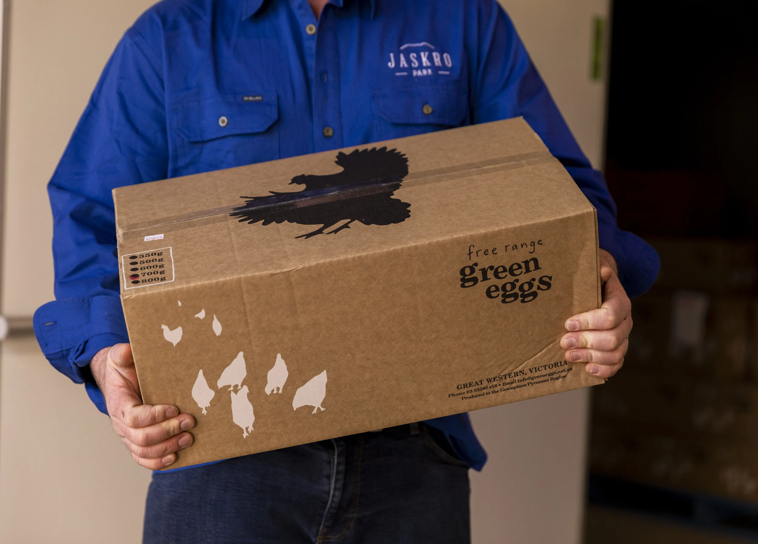 Staff member holding a box of eggs ready for delivery