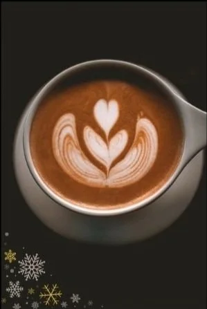 Latte art with heart and floral pattern in a coffee cup, black background, snowflake design in the corner.