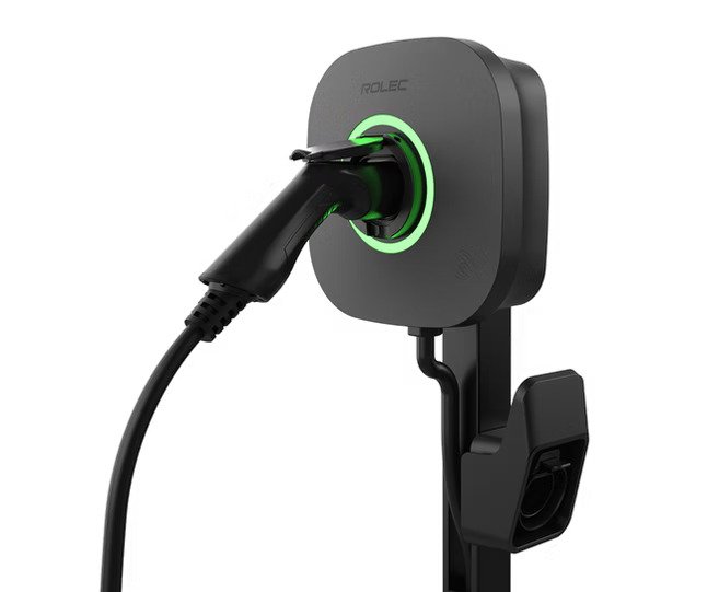 Electric vehicle charging station with a black and green charging connector plugged in.